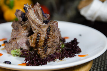 grilled lamb ribs decorated with green on a white plate