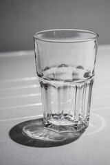 Sturdy looking empty glass tumbler on a white table.