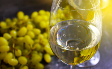 glass of white wine grapes on a concrete background