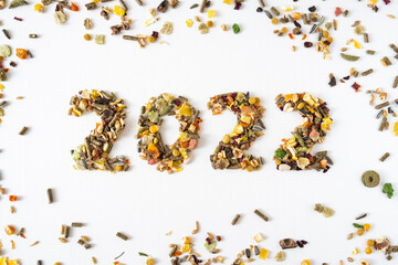 Number 2022 made of animal food isolated on white background with food grain around. Happy New Year or Christmas for animals concept.