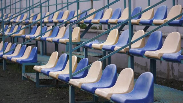 Empty spectator stands at the sports stadium. Plastic seats in blue and white without fans