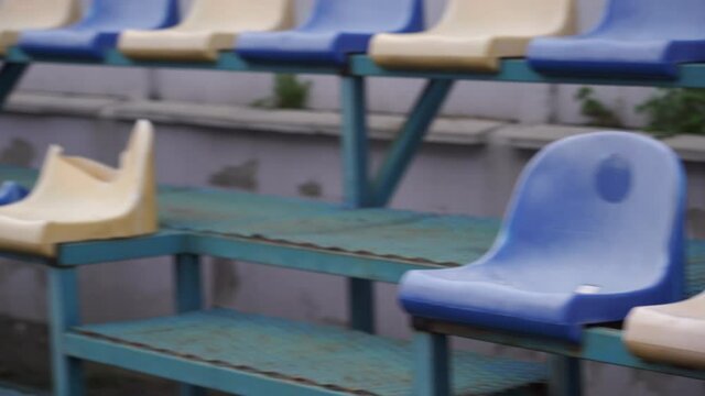 Empty spectator stands at the sports stadium. Plastic seats in blue and white without fans