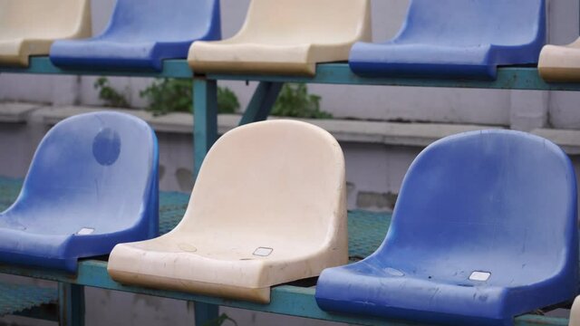Empty spectator stands at the sports stadium. Plastic seats in blue and white without fans