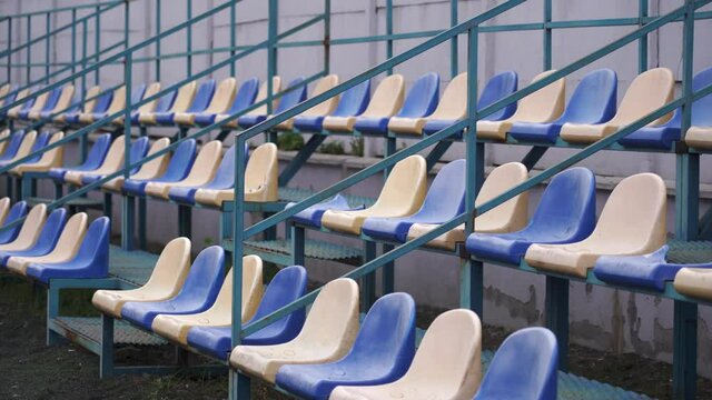 Empty spectator stands at the sports stadium. Plastic seats in blue and white without fans