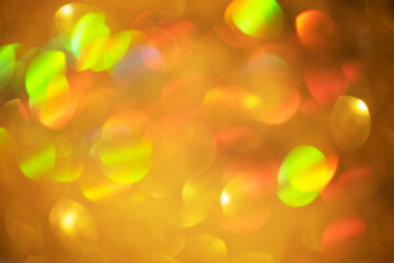 Golden abstract background. Defocus light sparkles of gold color as a background for designers.