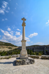 Fototapeta premium An obelisk with a cross standing at the top of a stone quarry