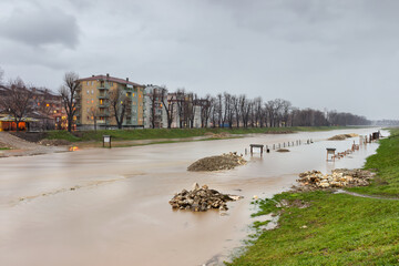 Muddy Nisava river is out of it's riverbank because of heavy rain and melted snow due to sudden weather change. Flood covered children playground and walking zone by the river - 459180747