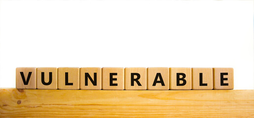 Vulnerable symbol. The word Vulnerable on wooden cubes. Beautiful wooden table, white background. Business and vulnerable concept. Copy space.