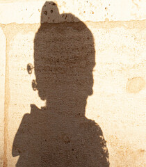 Sombra de mujer sobre un muro antiguo