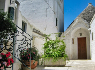 Fototapeta na wymiar The Trulli of Alberobello. Cozy Italian courtyard. White stone houses. Apulia. Italy. Europe 