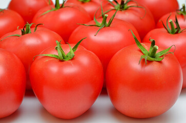 a lot of ripe red tomatoes on a white background