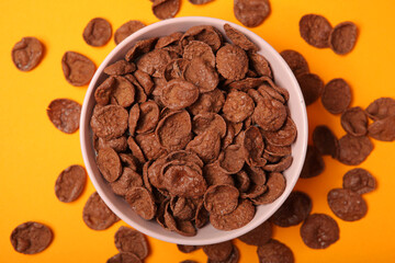 chocolate cornflakes for breakfast on colored background close up