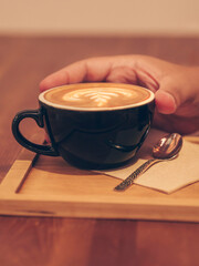 Man's hand drinking a cup of coffee