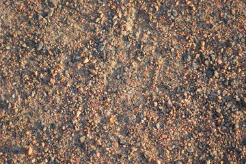 Dirt road made of small granite stones as a background.