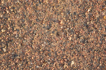 Dirt road made of small granite stones as a background.