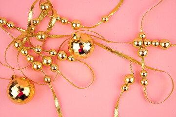 Golden beads on pink background copy space