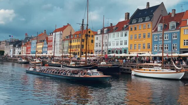 Scenic view of famous Nyhavn pier with colorful buildings and boats in Copenhagen, Denmark. The most popular and touristic place in Copenhagen.