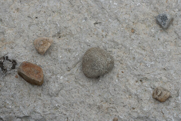 smaller rocks on a large stone outdoors - overcast skies