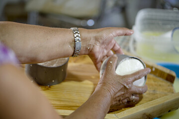 woman preparing homemade soft goat cheese