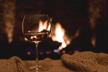Glass of white wine in front of fireplace