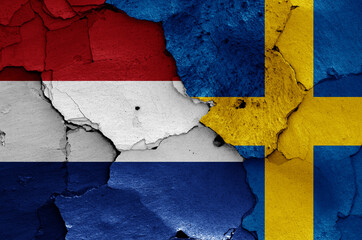 flags of Netherlands and Sweden painted on cracked wall