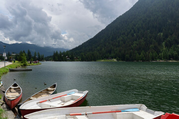 Rowing boats with paddles on a lake in the Swiss Alps along road. Cloudy day in the mountain