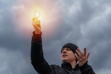 A man on a cold cloudy autumn day holding a vitamin D emitting sunshine