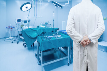 rear view image of doctors with stethoscope in a hospital pose arms crossed behind back looking at operating room of a modern hospital