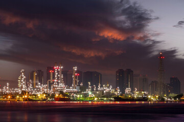 Oil refinery petrochemical industrial plant in twilight time against urban scene