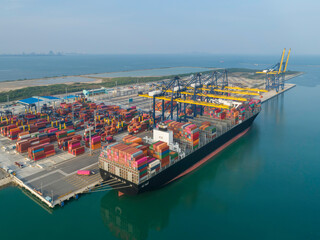 Aerial view of ship cargo containers entering to modern harbor with export and import business and logistics, world wide cargo transportation concept.