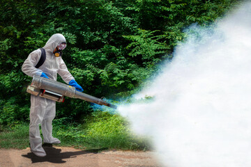 Health center staff spraying the smoke to get rid of mosquitoes at forest for stop spreading infections dengue fever and malaria