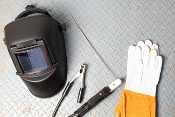 Welding equipment on a metal desk with workshop welding mask,Leather gloves,welding electrodes, for...