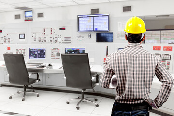 Technician holding blueprint for working at control room of a modern thermal power plant