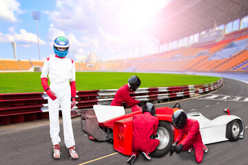 Race car driver posing in pit stop with engineers maintaining technical service for a racing car...