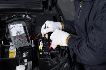 Auto mechanic uses a voltmeter to check the voltage level of a Car Fuse box, Control engine...
