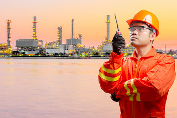 Engineer with radio communication in action for working at petrochemical oil refinery in sunrise