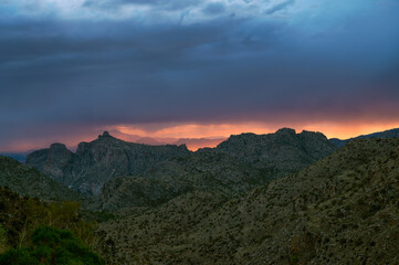 Fototapeta na wymiar Dramatic sunset sky with monsoon rain over Thimble Peak in Tucson
