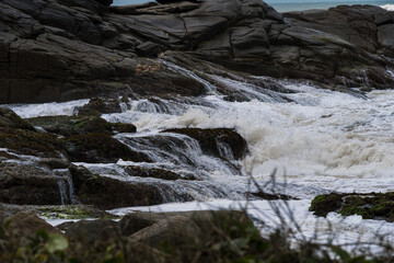 Strong waves crashing on the rocks of Rio das Ostras beach in Rio de Janeiro.