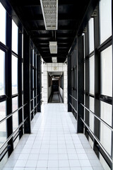 Inside the Enclosed walkway between luxury buildings around the corridor are glass windows to see the scenery outside in Thailand.