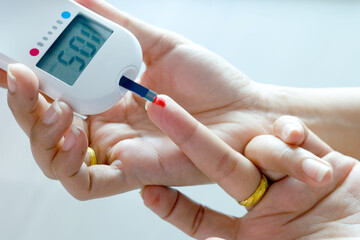 hand of people check diabetes and high blood glucose monitor with digital pressure gauge. Healthcare and Medical concept