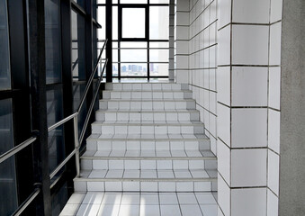 White tiled steps up to the upper floor, inside the building the bridge between the buildings in Thailand.