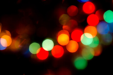 colored bokeh on a black background. christmas background. good New Year spirit.