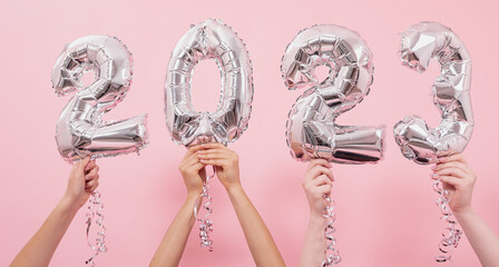 Festive balloons in from the numbers 2023 on a pink background.