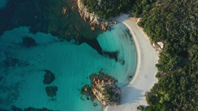 View from above, stunning aerial view of a green coast with the beautiful Prince Beach (Spiaggia del Principe) a white sand beach bathed by a turquoise water. Sardinia, Italy.