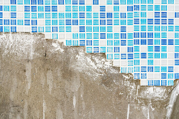 White and blue mosaic tiles with white seams the process of laying on a plastered wall. Top view