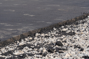 Fototapeta na wymiar Road works, freshly laid asphalt and gravel