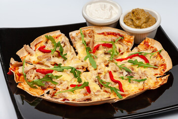 Pizza Tortilla with grated mozzarella, mushrooms, chopped red pepper and arugula