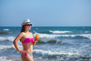 beautiful woman drinking cocktail on the beach