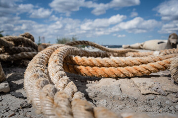 Fototapeta premium Old mooring rope on the pier close up abstract background.