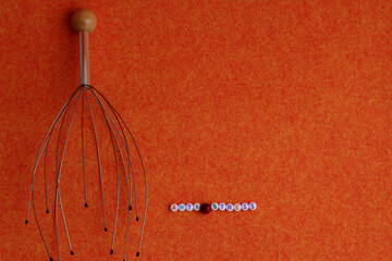 Head massager on an orange background orange and the inscription anti-stress